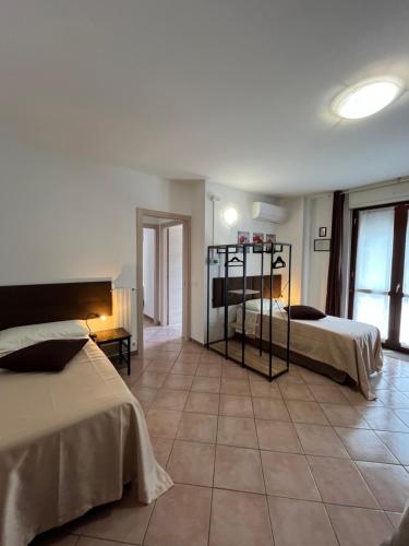 a bedroom with two beds and a tiled floor at Ferriera 8 in Novi Ligure