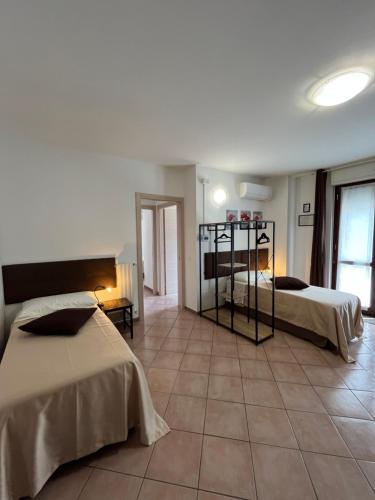 a bedroom with two beds and a tile floor at Ferriera 8 in Novi Ligure