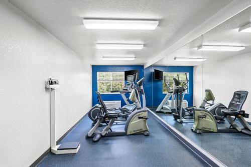 a gym with treadmills and ellipticals and a mirror at Microtel Inn & Suites by Wyndham Searcy in Searcy