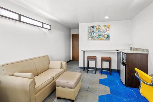 a living room with a couch and a kitchen at Microtel Inn & Suites by Wyndham Searcy in Searcy