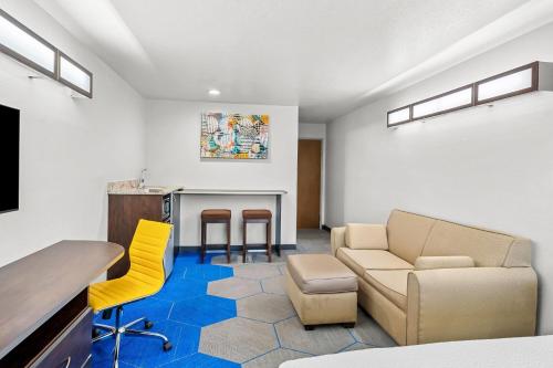 a living room with a couch and a table and chairs at Microtel Inn & Suites by Wyndham Searcy in Searcy