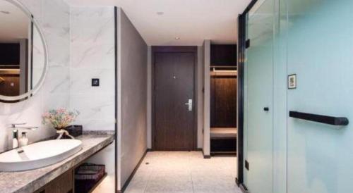 a bathroom with a sink and a mirror and a shower at Yitel Collection Lianyungang High-speed Railway Station Suning Plaza in Lianyungang