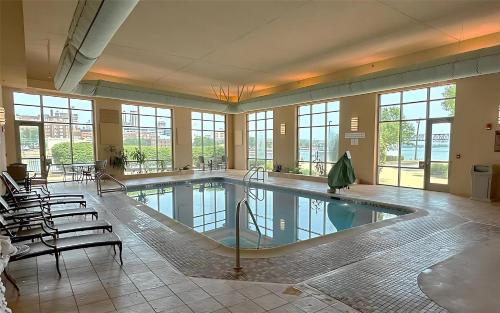 a large swimming pool in a building with windows at Embassy Suites East Peoria Hotel and Riverfront Conference Center in Peoria
