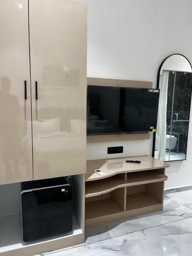 a bathroom with a cabinet with a mirror and a tv at Hotel The Octave in Surat