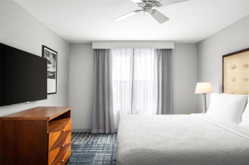 a hotel room with a bed and a flat screen tv at Homewood Suites by Hilton Dulles-North Loudoun in Ashburn