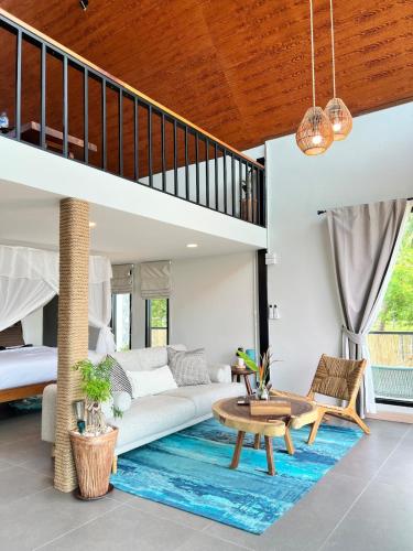 a living room with a white couch and a blue rug at GoldenHour House- Seaview & Sunset in Koh Phangan