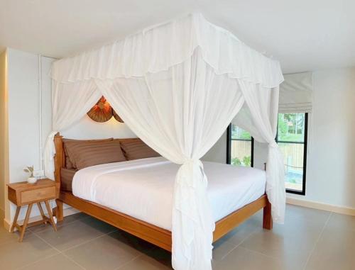 a bedroom with a canopy bed with white curtains at GoldenHour House- Seaview & Sunset in Koh Phangan