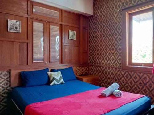a bedroom with a bed with a teddy bear on it at Mas Jenar Guesthose by Kawulastay in Timuran