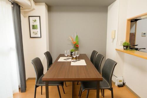 a dining room with a wooden table and chairs at SN4B ノワールネスト 都会のシックな隠れ家 Noir Nest urban chic retreat in Nagoya