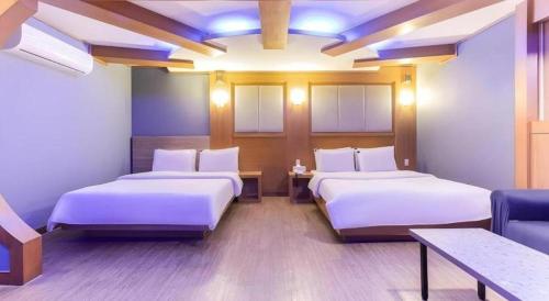 a hotel room with two beds and a couch at Hotel Head-One in Uijeongbu