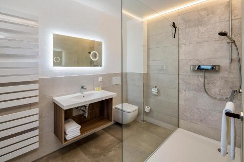 a bathroom with a toilet and a sink and a shower at Hotel Zur Post in Pirna