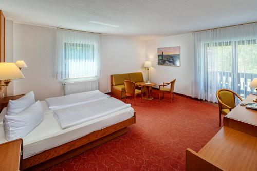 a hotel room with a bed and a table and chairs at Hotel Zur Post in Pirna