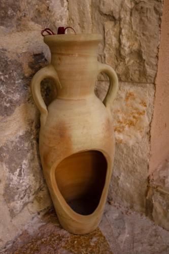 a wooden vase sitting in front of a stone wall at Ethno House Ivanovic in Virpazar