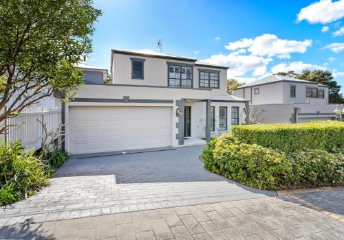 a large white house with a garage at Seaside Sanctuary in Kiama