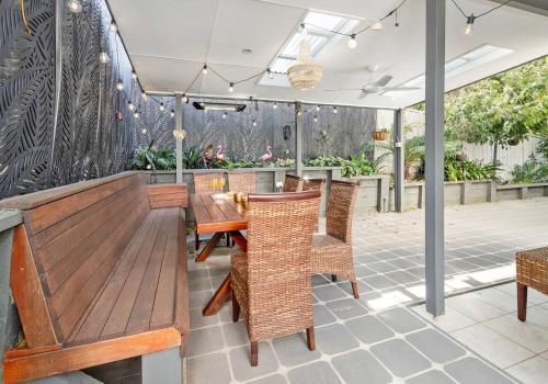 an outdoor patio with a wooden table and chairs at Seaside Sanctuary in Kiama