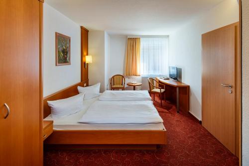 a hotel room with a bed and a desk at Hotel Zur Post in Pirna