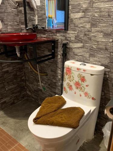 a bathroom with a toilet with two towels on it at Wanghin Bungalow in Surat Thani