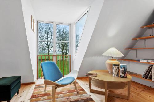 a living room with a blue chair and a table at AE202-Marstal-Baggarde-8 in Marstal