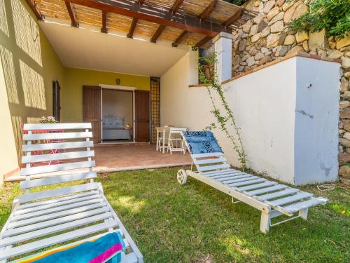 a pair of lounge chairs in the yard of a house at Ollastu Apartments Villasimius in Villasimius