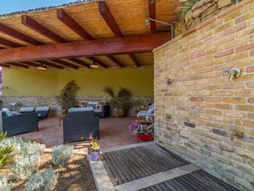 a patio with chairs and a brick wall at Ollastu Apartments Villasimius in Villasimius