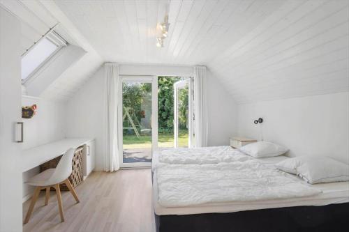 a bedroom with a bed and a desk and a window at AE240-Aeroskobing-Hanses-Ager-1 in Ærøskøbing