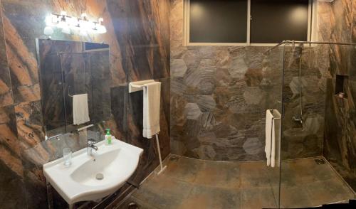a bathroom with a sink and a shower at Capital Grande in Dargai