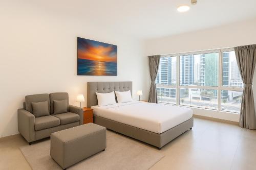 a bedroom with a bed and a chair at Marina Comfort Room with Bath inside in Dubai