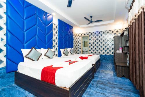a bedroom with two beds and a blue wall at RCH Hotels in Rāmeswaram