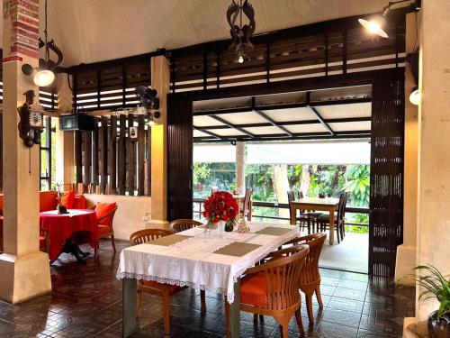 a dining room with a white table and chairs at Flora Ville-SHA PLUS in Chalong