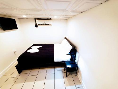 a bedroom with a bed with a black and white blanket at Nice 3BR Apt | 3 Beds |15 Min to NYC/Manhattan! in North Bergen