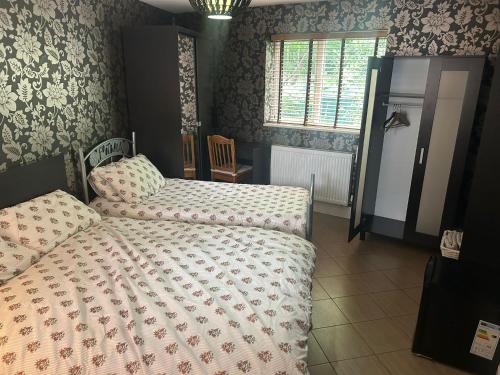 a bedroom with two beds and a window at 21 Fairfield Crescent in Edgware