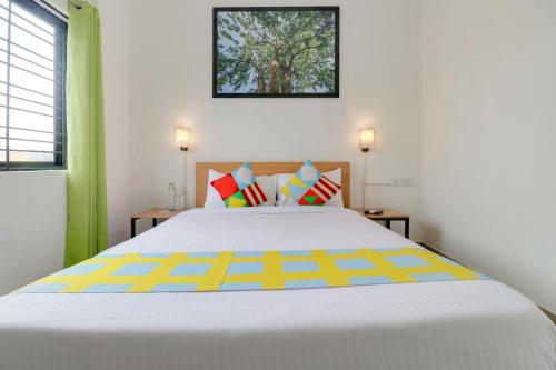 a bedroom with a large white bed with colorful pillows at Hotel IVY Residency in New Delhi