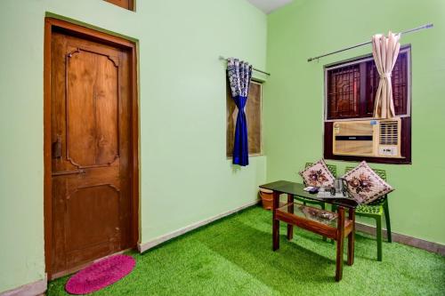 a room with a door and a table and green carpet at Hotel O Monalisa Guest House in Bhubaneshwar