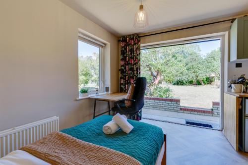 a bedroom with a bed and a desk and a window at Pass the Keys Charming and Central Garden Studio Flat Free Parking in Cambridge