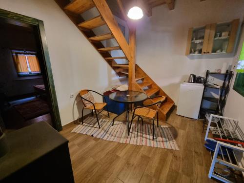 a room with a table and chairs and a staircase at Country House Sunčev breg in Bara Slatina