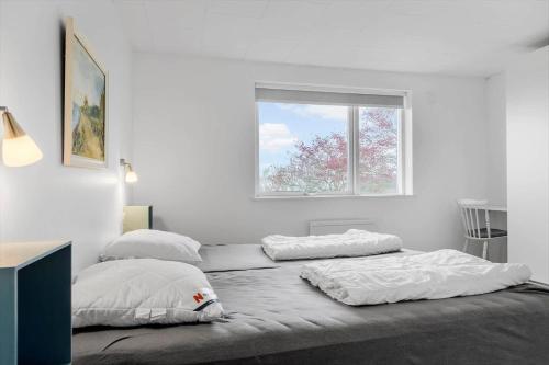 a white bedroom with two beds and a window at SB112-Augustenborg-Dyssevaenget-4 in Augustenborg