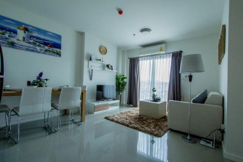 a living room with a table and a dining room at Baan Kiang Fah Apartment by Patcha in Hua Hin