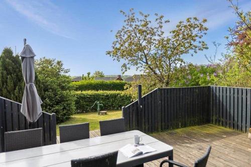 a wooden deck with a table and an umbrella at SB117-Nordborg-Oksbol-Sondergade-2 in Nordborg