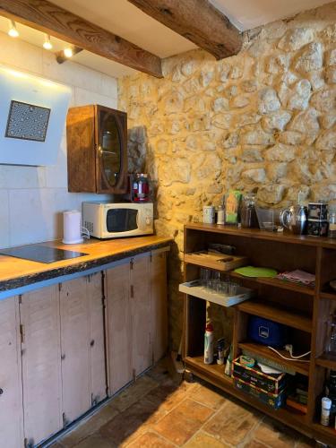 a kitchen with a counter top with a microwave at Studio indépendant tout équipé in Montpeyroux