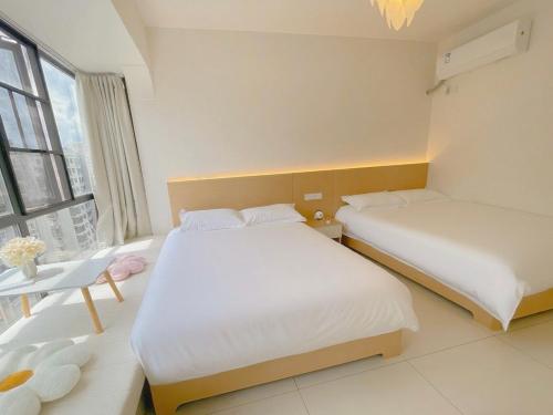 a bedroom with two beds and a window at 笑涡SmileNest Downtown Luxury Suite for 2-10 Guests, Zhangjiajie Attraction Ticket Service, Ideal for Couples, Families & Groups in Zhangjiajie