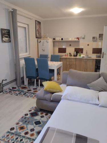 a living room with a couch and a table and a kitchen at Apartman All seasons in Sarajevo