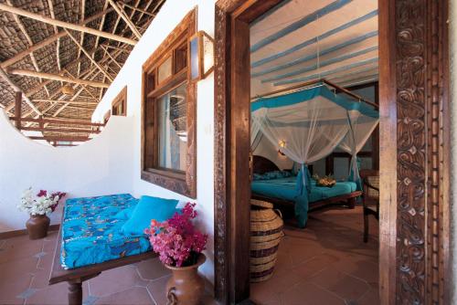 a living room with a bed and a couch at Hotel Club Dongwe in Pingwe
