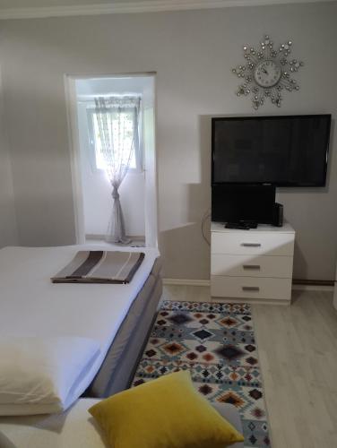 a bedroom with a bed and a flat screen tv at Apartman All seasons in Sarajevo