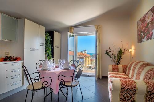 a kitchen with a pink table and chairs and a couch at Hotel Residence Amarcord in Rimini