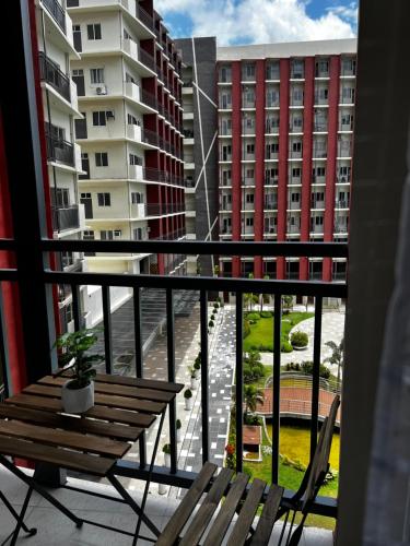 Mactan IslandにあるDagos PrimeWorld condo with balcony and pool viewのベンチ付きのバルコニーから建物の景色を望めます。