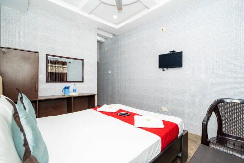 a bedroom with a bed and a tv on the wall at RCH Hotels in Rāmeswaram