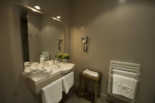 a bathroom with a sink and a mirror and towels at Hotel et restaurant Le Clos De La Prairie in Gouy-Saint-André