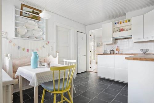 a kitchen with a table and yellow chairs in a room at TV1625-Albaek-Samsovej-10 in Ålbæk