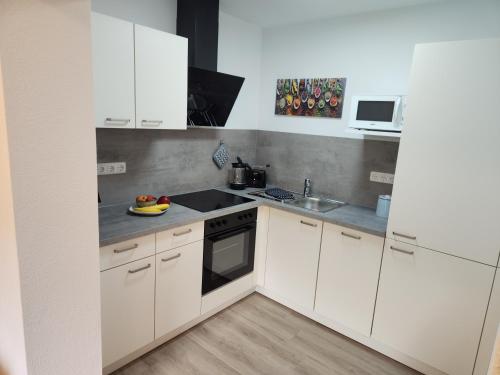 a white kitchen with white cabinets and a sink at Winzerhof Düring in Iphofen