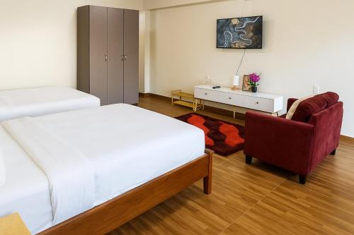 a bedroom with a bed and a chair and a desk at Vailoa 1bedroom, 5 min to Apia, AC, Wi-fi, kitchen in Apia